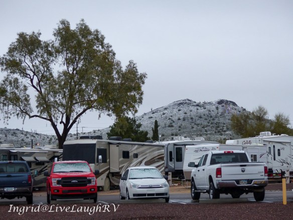 an RV park in Phoenix, Arizona with a snow coated hill in the background