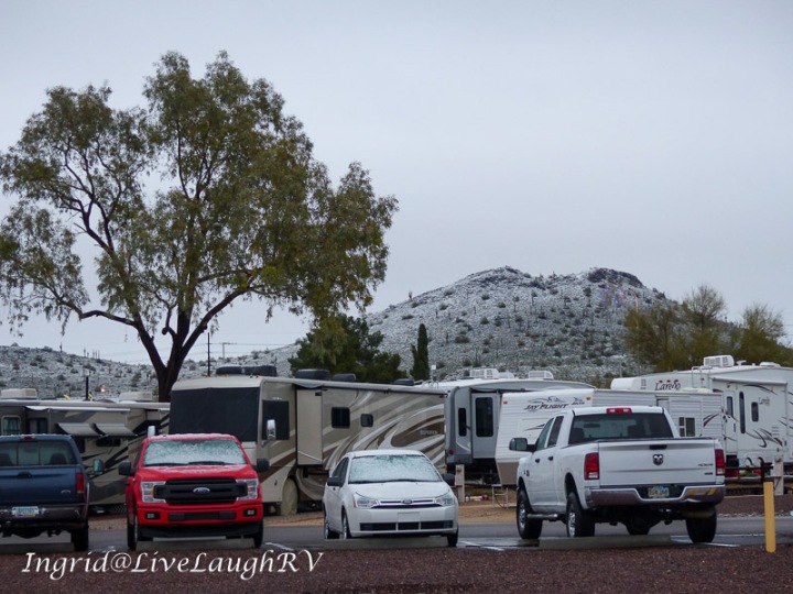 an RV park in Phoenix, Arizona with a snow coated hill in the background