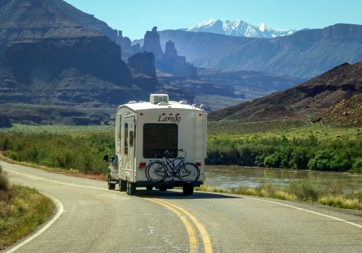 RV traveling down the road with scenic Moab, Utah in the background