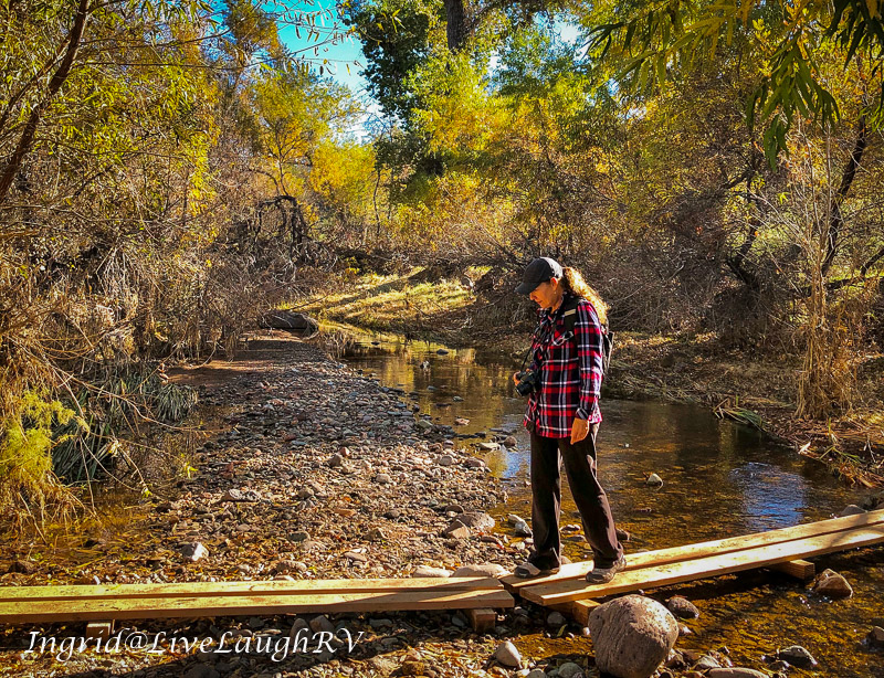 a female hiking across a creek in Arizona
