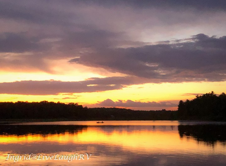 a canoe on a lake at sunset
