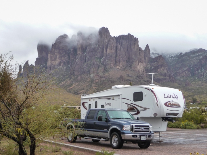 an RV camped at the base of the cloud covered Superstition Mountains with 